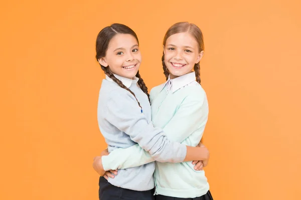 最好的朋友 聪明的小女孩在黄色的背景 教育理念 回到学校知识日 童年的幸福 儿童时尚 友谊和姐妹情谊 穿着校服的快乐女孩 — 图库照片