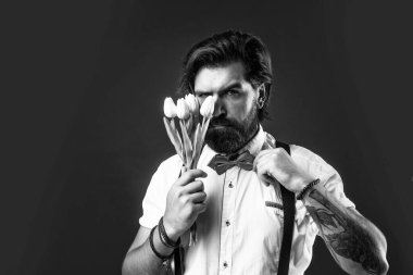 Tarz sahibi vahşi sakallı erkek lale buketi tutuyor, anneler günü..