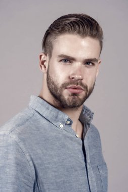 Mavi gömlekli sakallı adam. Tıraşsız yüzü deri üzerinde sakallı adam. Cilt Bakımı ve Saç Bakımı güzellik salonu. Moda veya stil ve eğilim. Güven ve karizma.