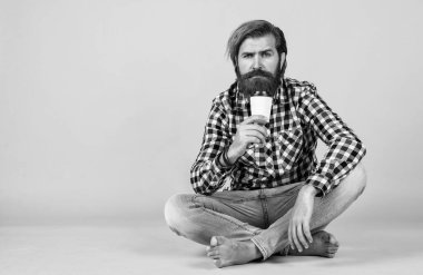 Bir fincan kahve ya da çay al. Yaşam tarzı konsepti. Kahveli yakışıklı hippi adam. Kahve molası veriyor. Fincandan su içen yakışıklı bir yetişkin. kopyalama alanı. Boşluğu kopyala.