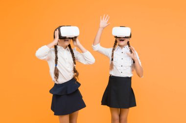 Yeni deneyimlerin tadını çıkar. Mutlu çocuklar modern teknolojiyi kullanır. Gelecekteki eğitim. Okula dönüyorum. Dijital gelecek ve yenilik. Sanal gerçeklik. VR kulaklıklı küçük kızlar. Çocuklar kablosuz VR gözlük takıyor.