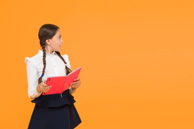 Dil eğitimi. Evde çalış. Ders kitabı ile sevimli çocuk çalışması. Okul çalışmaları için okuma becerilerini pratik edin ve geliştirin. Okul konseptine geri dönelim. Kız kitap tutun. Sarı arka planda okul kız.