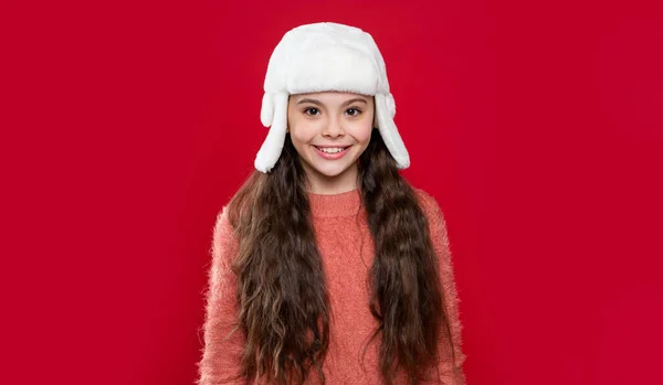 少女的冬季时尚 冬季针织物 戴耳瓣帽的少女模特 戴着冬季帽子的少女被红色背景隔离了 在演播室里 少女穿着毛衣 头戴冬帽 — 图库照片