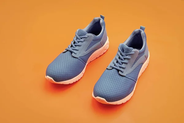 Sportliche Blaue Turnschuhe Paar Auf Orangefarbenem Hintergrund Sport — Stockfoto