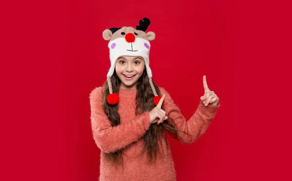 スタジオでは10代の子供がセーターと冬のファッションの帽子のポイント指を着用 10代の子供の冬のファッション 冬のイヤフラップ帽子の10代の子供ファッションモデル 冬のファッションの帽子の10代の子供は — ストック写真