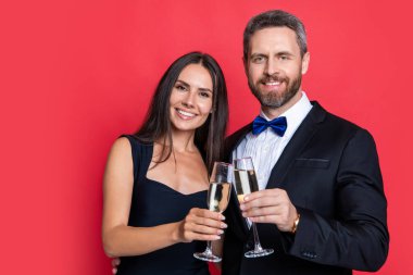 Beyaz arka planda izole edilmiş resmi smokinli çiftin tezahüratları. Resmi smokinli çift, şerefe. Resmi smokinli çiftin tezahüratlı bir stüdyo resmi. Zarif çift resmi smokin giyer. Şerefe konsepti.