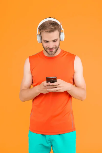 턱수염을 남자는 일하기 운동복을 네트워크를 사용하는 사용하여 디지털 이어폰으로 음악을 — 스톡 사진
