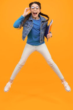 Tatil eğlencesine. Tatil zamanı. Okul tatilindeki mutlu kız. çocukluk mutluluğu. Bilgi günü konsepti. Özgürlük, hareket ve insanların konsepti. Neşeli çocuk havaya zıplıyor.