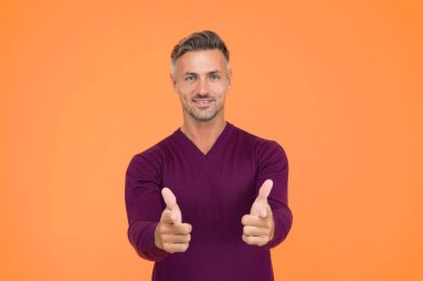 Sadece sen. Sarı arka planı olan yakışıklı bir adam. Parmakla işaret eden mutlu adam. Gösterişli el hareketi. Düz tut. Parmak tabancası ya da tabanca. Ürün reklamcılığı ve satış konsepti.