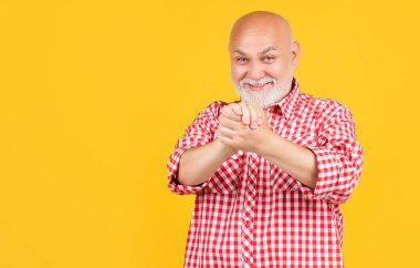 Sarı arka planda damalı gömlekli yaşlı adam ya da büyükbaba.