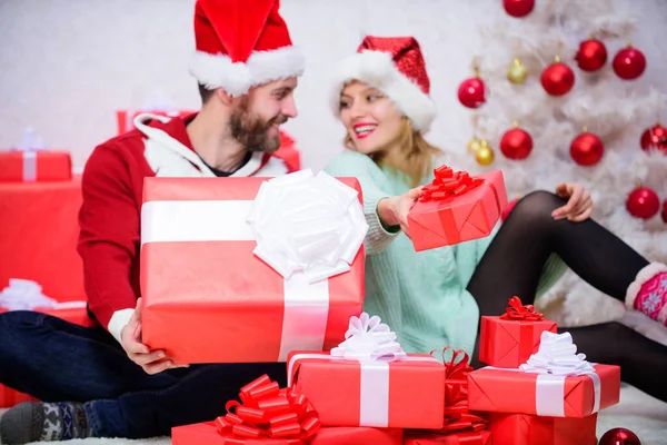 一家人在家里结婚 恋爱中的夫妻享受寒假庆祝 恋爱中的女人和满脸胡须的男人坐在圣诞树旁 平安夜与亲爱的 爱情是最好的礼物 图库照片