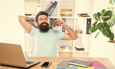 Mutlu iş adamı kahve içiyor, ofis masasında dinleniyor, mola veriyor..