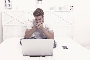 Evde kal. Beyaz adam laptoptan yatakta çalışıyor. Çevrimiçi kurslar. İnternet işi. Modern iletişim. Bilgisayar teknolojisi. İnternet sörfü. Video konferansı. Dijital pazarlama. Covid-19 tecrit.