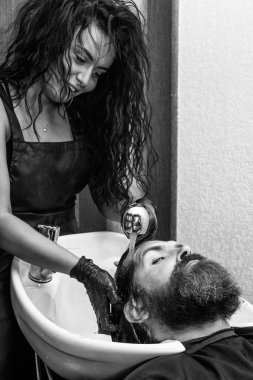 Berber berber dükkanında, berber salonunda adamın saçını yıkar..