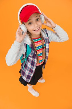 Müzik kulaklıkları dinleyen sevimli hippi ergen. Sarı arka plan. Havalı liseli. Gençlik modası. Neşeli bir genç. Küçük kız uzun saçlı. Ergen yaşam tarzı. Modern bir genç. Mutlu çocukluk.