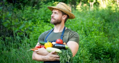 Hasır şapkalı adam taze olgun sebzeleri tutuyor. tarımsal.