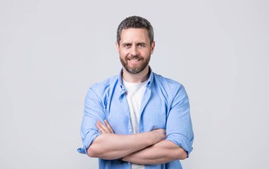 Sıradan bir gömlek giyen beyaz bir adam. Gri arka planda izole edilmiş günlük tarzda beyaz bir adam. Stüdyoda kirli sakalı olan sıradan bir beyaz adam. Kafkasyalı adamın resmi. Rahat giyin..