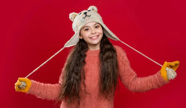 イヤーフラップ ハットの10代の子供モデル 赤いスタジオの背景に隔離された耳フラップの帽子の10代の子供 スタジオでは10代の子供がセーターとイヤーフラップの帽子を着用します 10代の子供の冬のファッション イヤーフラップハット ニットウェア — ストック写真