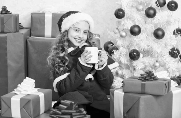 女の子の小さな愛らしい子供はクリスマスを祝いながら熱い飲み物でマグカップを保持します クリスマスの前夜にホットココアを飲む ココア好きな飲み物 子供のサンタの帽子は熱い飲み物を楽しむ 子供のためのおいしい暖かい飲み物 — ストック写真