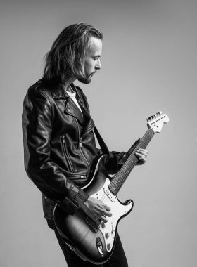 Sert kaya. Rock müzik tarzı. müzisyen gitarist. ustaca müzik çalıyordu. Modaya uygun çılgın adam. müzik enstrümanı. Deri ceketli sakallı rockçı. Uzun saçlı adam elektro gitar çalıyor..