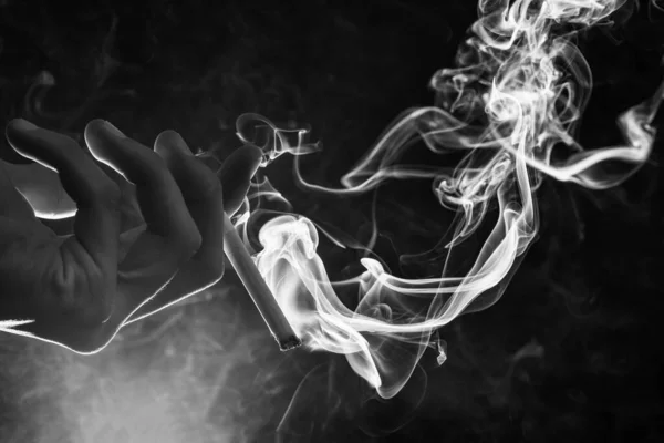 Mano Masculina Sostiene Cigarrillo Ardiente Con Remolino Humo Fondo Oscuro — Foto de Stock