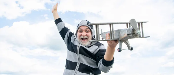 グリズル シニア引退した男 定年退職した男だ おもちゃの飛行機の屋外で空の背景の老人 — ストック写真