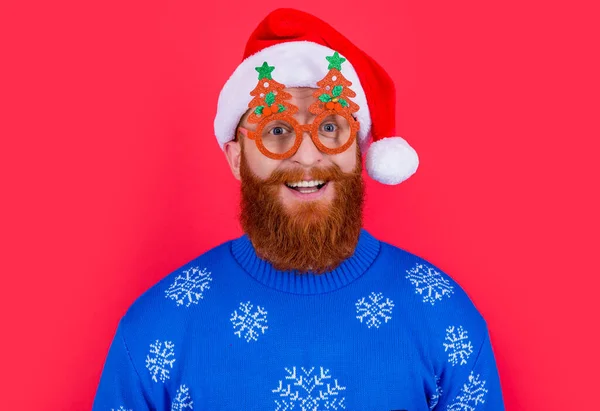 クリスマスパーティーの楽しみ パーティーグラスの中の幸せな男はクリスマスに楽しい時間を過ごす サンタさんは赤を背景に隔離されたクリスマスパーティーで楽しんでいます — ストック写真