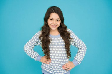 Harika bir saç stili. Mutlu kız dalgalı saç stili mavi arka plan giyer. Uzun esmer saçlı küçük bir çocuk. Güzel saç stili. Yeni saç stilin. Güzellik kuaförü.