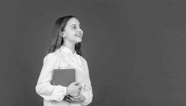 Okula dönüyorum. Çocuk çalışmaya hazır. Mutlu çocukluk. Çocuk ödevlerini kitapla yapacak. Genç bir öğrenci. Lisede eğitim. Kitapçığı olan liseli kız. kopyalama alanı. Defteri olan genç kız..