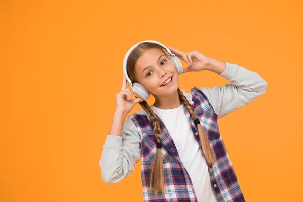 現代的なヘッドフォンを身に着けている幸せな女の子 ステレオサウンドを楽しむかわいい子供 無線は自由を意味する無線技術を搭載したヘッドフォン 小さな子供は音楽を聴く現代のワイヤレスイヤフォン — ストック写真