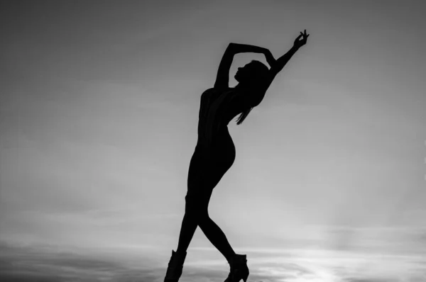 silhouette of sensual woman dancing in dusk, freedom.