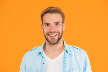 Mutlu stil sahibi, tıraşsız bir adam sarı arka planda günlük gömlek giyer, erkek güzeli..