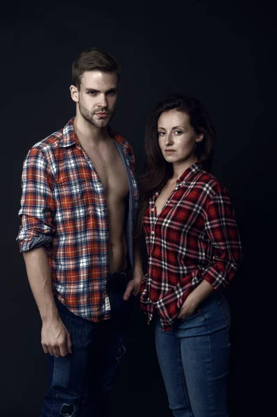 Family look. Similar outfits. Couple wear checkered shirts. Rustic hipster style. Handsome man and woman looking similar in family style clothes. Casual and comfortable. Family posing photo session.
