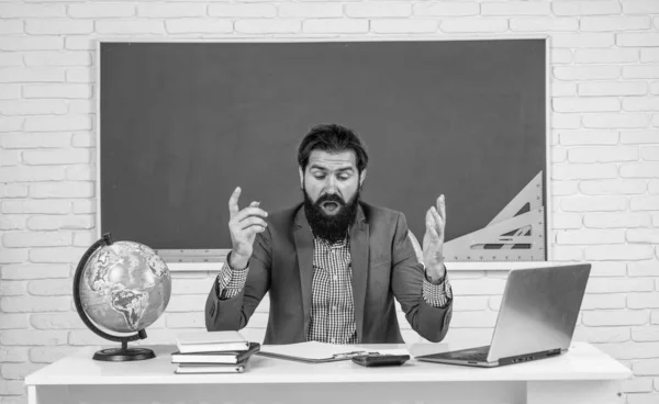 mature bearded man teacher in costume sit in school classroom with geography globe map, destination.