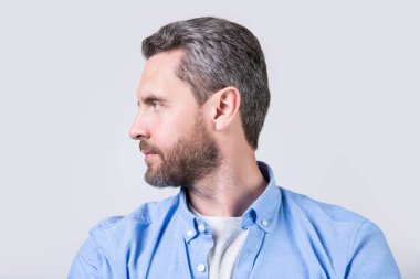 Gri arka planda sakallı, beyaz sakallı adam. Stüdyoda sakallı bir adam var. Sakallı bir adamın fotoğrafı. Sakallı, sakallı, sıradan gömlekli bir adam..