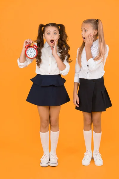 学校の時間だ 女子高生と目覚まし時計 子供の学校の生徒 知識の日だ 驚くべきショックを受けた子供たちは目覚まし時計計時時間を保持します ラテコマーは処罰される 時間です 学校のスケジュール — ストック写真