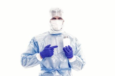 Tıbbi koruma altındaki doktor COVID-19 koronavirüs hastalığı semptomları için ilaç şişesini işaret ediyor. Solunum sendromu SARS-CoV-2, ilaç tedavisi..