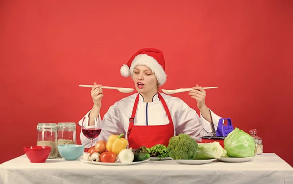 Easy ideas for christmas party. Healthy christmas holiday recipes. Festive menu concept. Woman chef santa hat cooking hold wooden spoons. Best christmas recipes. Christmas dinner idea. Try main meal.