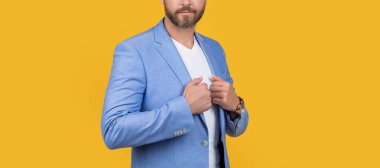 Stüdyodaki adam görüntüsü. Takım elbiseli yakışıklı bir adamın fotoğrafı. Resmi ceket giyen bir adam. Sarı arka planda yalıtılmış beyaz ceketli adam..