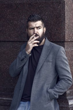 Vahşi, olgun, bıyıklı, dışarıda sigara içen, modaya uygun, gündelik ceketli, kötü alışkanlığı olan bir adam..