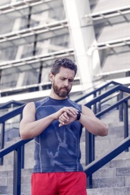 Sağlıklı yaşam ve kendini kontrol kavramı. Fitness hedeflerine ulaşmak için. Dostum, nöbet zamanı. Adam yarıştan önce GPS saatini ayarlıyor. Egzersiz sırasında sağlık kontrolü teknolojisi kavramı.