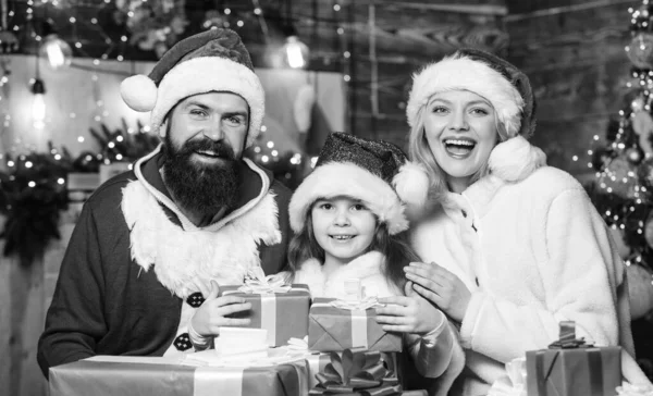 一緒にクリスマス 父と母は娘を愛する クリスマスプレゼント箱 プレゼントを開けなさい サンタ ハットの小さな子供と両親 冬休みだ 買い物の販売 幸せな家族は新年を祝う — ストック写真