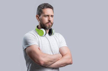 Kulaklıkla müzik dinleyen adam gri arka planda izole edilmiş. Adam stüdyoda kulaklıkla müzik dinliyor. Modern kulaklıkla müzik dinleyen bir adam. Kulaklıkla müzik dinleyen bir adamın fotoğrafı..