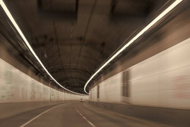 Modern yeraltı tüneli. Gri yol tüneli. Şehir yeraltı köprüsü. Gri tüneller koridoru. Hareket eden araba yerin çok altından aydınlatılmış şekilde geçiyor. Işık yolları. ulaşım arkaplanı.