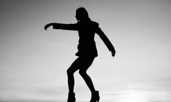 female silhouette on sunset sky background of dancing woman, silhouette.
