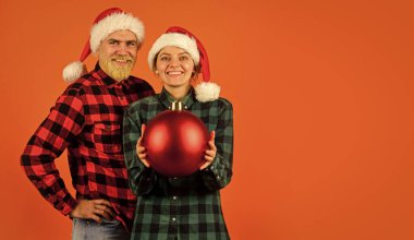 Yetişkinler için eğlence fikirleri. Noel Baba takımı. Sevgili turuncu arka plan çifti. Sihirli Noel zamanı. Noel 'i seviyoruz. Birbirine aşık çiftler Noel kutlamalarının tadını çıkarırlar. Aile Noel Baba şapkası takar..