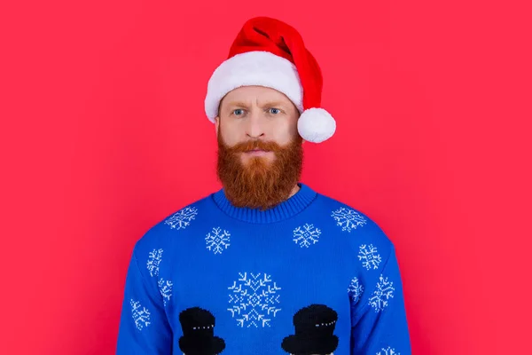 陽気なクリスマスを Xmasセーターの白人の真剣な男と赤い背景に隔離されたサンタの帽子 クリスマスパーティーの男 — ストック写真