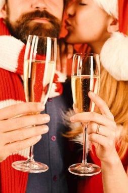 Noel Baba ve seksi kız, içki içip sarılıyorlar. Noel partisi konsepti. Sakallı bir adam ve arka planda romantik yüzlü bir kadın, dikkati dağılmış. Birbirine aşık çiftler şampanya bardaklarını tutar..