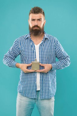 Olgun erkek hippi mavi arka planda şişeden parfüm kokusu kullanıyor..