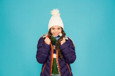 Rahatım yerinde. Soğuk sezon alışverişi. Koruyucu ceketli bir çocuk. Mevsimlik moda. Kış tatili Moda kızı kışlık giysileri. Moda modası. Çocuk mavi arka plan şapkalı ve ceketli. Kış sporları.